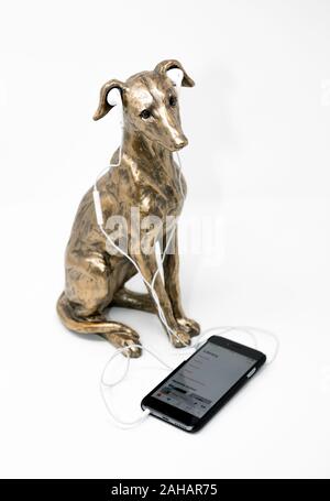 Bronzo lega verniciato modello di un whippet con iphone e earpods. Foto Stock