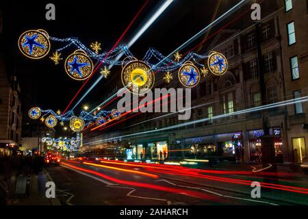 Percorsi di luce tra le decorazioni di Natale sul trefolo nel West End di Londra Foto Stock
