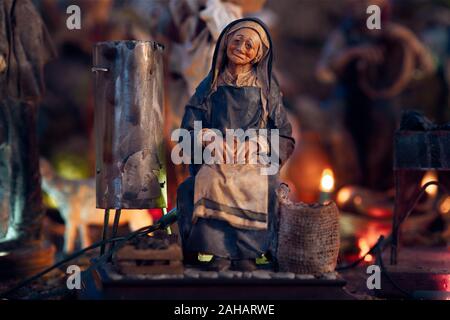 Presepe rappresentato con statuette. Close-up della statuetta di una donna al lavoro. Foto Stock