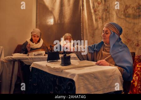 L'Italia, sicilia, Partinico, Dicembre 22/2019, bellissimo presepe vivente nel quartiere Parrini, donne ferro e cucire i tessuti Foto Stock