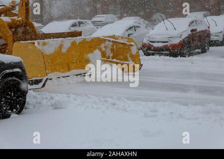 Spartineve la rimozione di neve dal parcheggio per auto neve invernale sullo sfondo Foto Stock