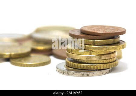 Close-up di una pila di monete in euro impilate senza fine su un tavolo bianco Foto Stock