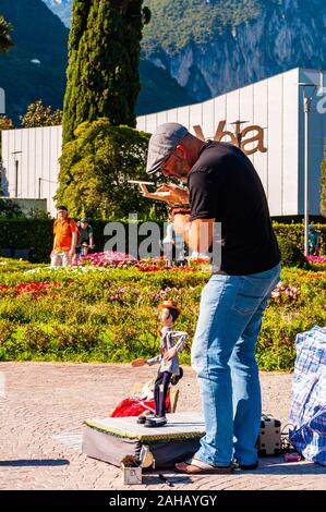 Riva del Garda, Lombardia, Italia - 12 Settembre 2019: l'artista burattinaio eseguendo con la sua bambola sulla passeggiata del lago di Garda in Riva del Garda city Foto Stock