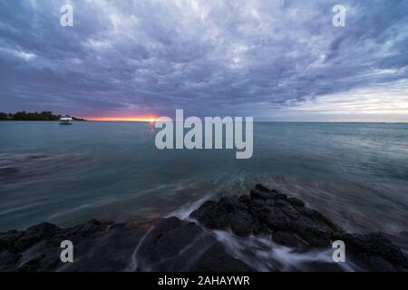 Drammatica cielo nuvoloso al tramonto sull'oceano onde, Grand Baie (Pereybere), l'Oceano Indiano, a nord-ovest della costa, Mauritius Foto Stock