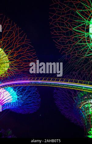 Illuminato gigante artificiale alberi Super sostare di fronte alla Marina Bay Sands, a giardini dalla Baia di Singapore Foto Stock