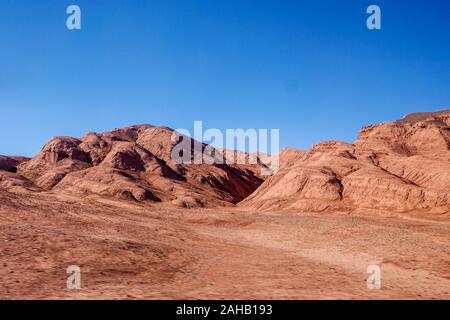 Una mandria di vigogne passano attraverso il rosso delle colline del Desierto de Laberinto, o labirinto deserto, a Tolar Grande in alta altitudine altiplano puna deserto vicino a Salta in Argentina Foto Stock