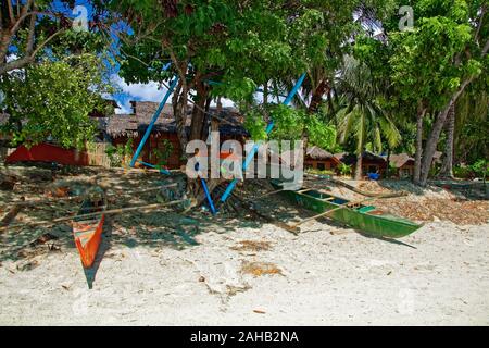 Vecchie barche con vernice pelata, circondato rubbishes sul bordo della spiaggia Dumaluan nelle Filippine, Panglao Island Foto Stock