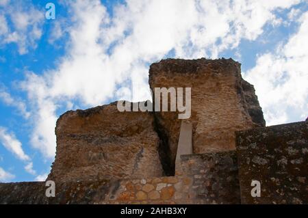 Due grandi pezzi di pietra di antico edificio romano e muro di pietra. Cielo blu con nuvole come sfondo. Italica, Siviglia, Spagna Foto Stock