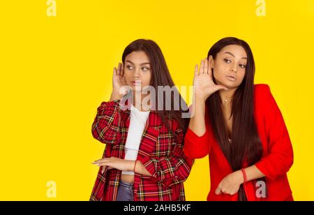 Closeup ritratto nosy giovani donne mano a orecchio attentamente il gesto attentamente ascolto segretamente succosa conversazione gossip news violazione della privacy isolato Foto Stock