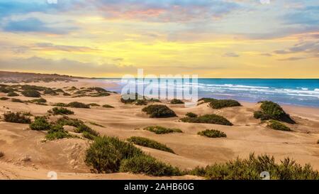 Paesaggio al tramonto a Agadir, Marocco, dove il deserto di sabbia si trasforma in una spiaggia all'Oceano Atlantico. Foto Stock