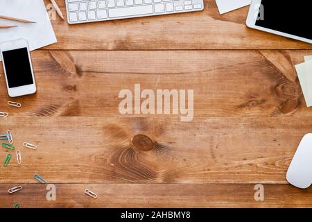 Dispositivi aziendali fornisce sulla scrivania in legno ufficio sfondo, vista dall'alto Foto Stock