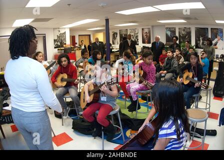 Cheryl Jones, insegnante di musica, conduce una classe di chitarra mentre l'agricoltura Sotto Segretario Kevin W. Concannon e altri ospiti osserva i progressi a Elsie Whitlow rifornisce Comunità Libertà Pubbliche Scuola Charter, mercoledì 2 febbraio, 2011 a Washington D.C. Foto Stock