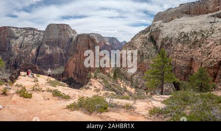 Famiglia seduti sul promontorio che sovrasta Angel's Landing escursione al Parco Nazionale Zion, Utah, Stati Uniti d'America, molla Foto Stock