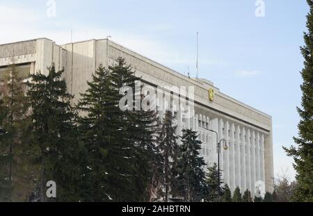 Almaty. 28 dicembre, 2019. Una bandiera nazionale del Kazakistan vola a mezz'asta sopra il palazzo del governo di Almaty in Kazakistan, Dic 28, 2019. Il piano della compagnia aerea kazaka Bek aria, voce da Almaty ad Nur-Sultan, scomparso dal radar dopo il decollo. L'aereo di linea ha perso la sua altezza e si è schiantato in un edificio a due piani. Secondo i dati dell'aviazione civile Comitato del Kazakistan, vi erano 95 passeggeri e 5 membri di equipaggio a bordo del velivolo. Almeno 12 persone sono state uccise e decine di feriti in crash. Credito: Kalizhan Ospanov/Xinhua/Alamy Live News Foto Stock