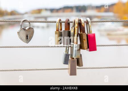 Gruppo di blocchi appeso sul ponte finlandese come simbolo di amicizia Foto Stock