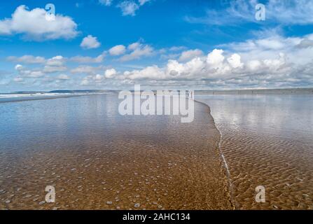 Cielo blu e sabbia bagnata su Westward ho! Spiaggia, Regno Unito Foto Stock