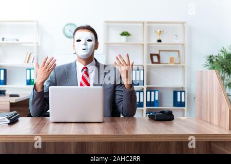 L uomo d affari che indossa la maschera di ipocrisia concept Foto Stock