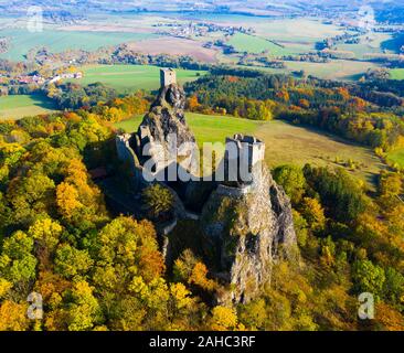 Vista aerea dell'antica rovina il castello Trosky alta sui vertici di basalto due tasselli vulcanici sullo sfondo del paesaggio autunnale del Paradiso Boemo, ceco Foto Stock