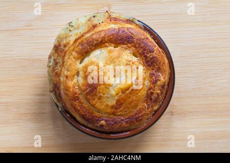 Tirato prosciutto e formaggio torta salvadanaio da M&S raccolta alimentare impostato su sfondo di legno Foto Stock