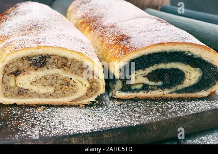 Semi di papavero di rullo e rullo wallnut sul tavolo di legno Foto Stock