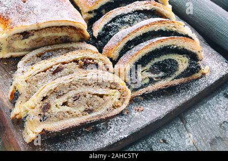 Semi di papavero di rullo e rullo wallnut sul tavolo di legno Foto Stock