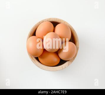 Fresca bruna le uova nella ciotola di legno Foto Stock