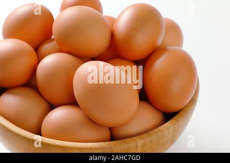 Fresca bruna le uova nella ciotola di legno Foto Stock