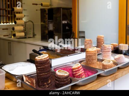 Ceca tradizionale trdelnik sulla strada del mercato vetrina - dolce pasticceria spit da grigliate di impasto arrotolato con zucchero, noce e irrorazione colorati Foto Stock