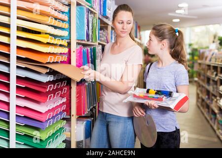 Attraente Giovane Donna con bambina preteen visitando il negozio di articoli di cancelleria in cerca di forniture scolastiche Foto Stock