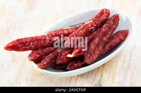 Tradizionale catalana salatura a secco mini salsiccia secallona su sfondo di legno Foto Stock