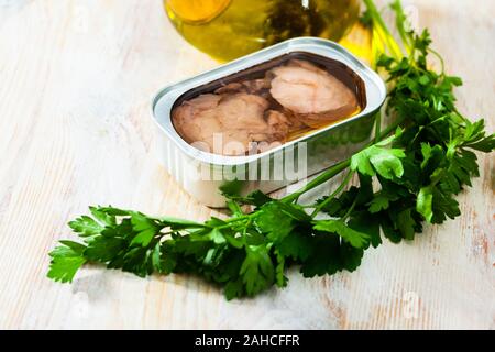 Affumicato di fegato di merluzzo bianco in olio di aprire il barattolo di latta con verdure fresche su un tavolo di legno. Frutti di mare delicatezza Foto Stock