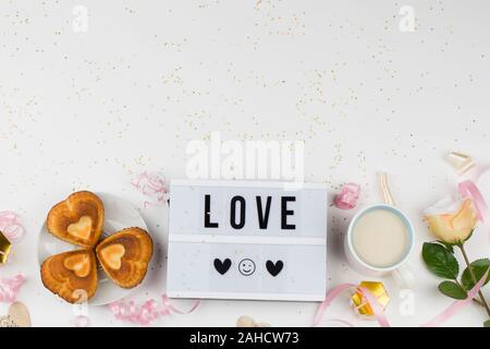 Light box con testo amore, decorazione, Tortine a forma di cuore, fiori, Tè con latte e nastro. amore confessione, felice il giorno di san valentino, copia spazio per Foto Stock