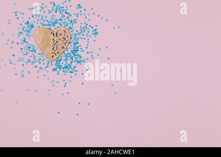 Cuore di legno con disegni su sfondo rosa con stelle blu top view flat laici spazio di copia Foto Stock