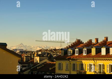 Vista sui tetti del centro della città di Torino con le Alpi mountain range in background contro il cielo di sunrise, Piemonte, Italia Foto Stock