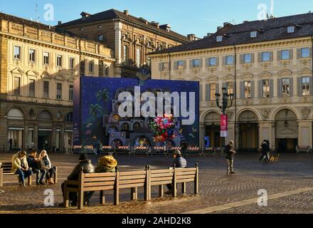 Piazza San Carlo Piazza con gente seduta sulle panchine sotto il sole e la grande calendario dell'Avvento durante le vacanze di Natale, Torino, Piemonte, Italia Foto Stock