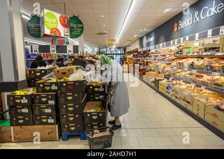 Gli acquirenti di generi alimentari in un supermercato LIDL sempre loro festosa il cibo ed il vino prima del giorno di Natale, England, Regno Unito Foto Stock