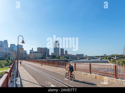 Lo skyline del centro cittadino dall'arco in pietra con Bridge St Anthony Falls a destra del fiume Mississippi, Minneapolis, Minnesota, Stati Uniti d'America Foto Stock