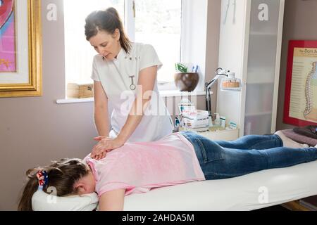 Massaggio sportivo terapista trattare la ragazza adolescente Foto Stock