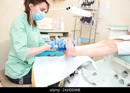 Piedi della donna che ricevono un pedicure. Estetista facendo pedicure. Primo piano. Foto Stock