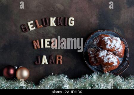 La Felice Anno Nuovo wisch in olandese con la delicatezza nazionale chiamato oliebollen dougnut o sfere. Foto Stock