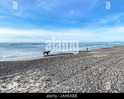 Surfer a piedi con i loro schede su Torrey Pines State Beach prima del tramonto twilight, costiere Beach si trova a San Diego, California. Dicembre 12th, 2019 Foto Stock