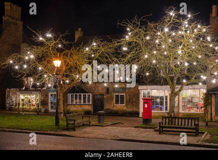 Le decorazioni di Natale lungo la high street a Broadway di notte. Broadway, Cotswolds, Worcestershire, Inghilterra Foto Stock