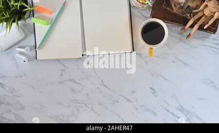 Vista dall'alto ufficio di marmo con libri, taccuino, matita, caffè, gli auricolari con office gadget. Foto Stock