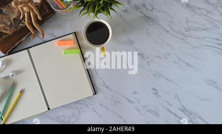 Vista dall'alto ufficio di marmo con libri, taccuino, matita, caffè, gli auricolari con office gadget. Foto Stock