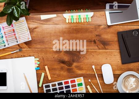 Moderno design creativo concetto Workplace, computer pitture su legno bruno tabella Foto Stock