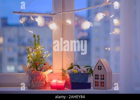 Albero di Natale decorazioni di Natale, candele e regali di Natale su un davanzale Foto Stock