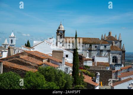 In Dacharchitektur Monsaraz mit einer Kirche im Hintergrund Foto Stock