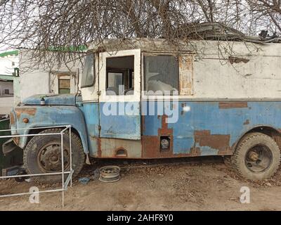 Un vecchio due-tono bus abbandonato coperto di ruggine Foto Stock