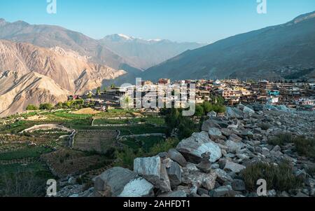 Nako villaggio fiancheggiato da campi, alta montagna himalayana, e sentiero roccioso nella Spiti valley a sunrise in Himachal Pradesh, India. Foto Stock