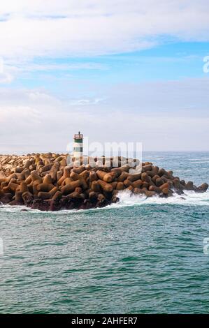 Il faro all'entrata del porto, nazare, Portogallo Foto Stock